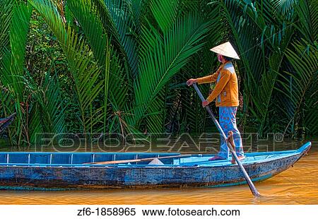 Vietnam, Saigon, Mekong Delta swamps, Woman wearing straw hat in boat View Large Photo Image Stock Photography - Vietnam, Saigon, Mekong Delta swamps, Woman wearing straw hat in boat. Fotosearch