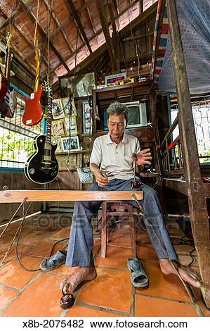Vietnamese man playing home built instrument at My An Hung Village, Mekong River Delta, Vietnam. View Large Photo Image Stock Image - Vietnamese man playing home built instrument at My An Hung Village, Mekong River Delta, Vietnam.. Fotosearch