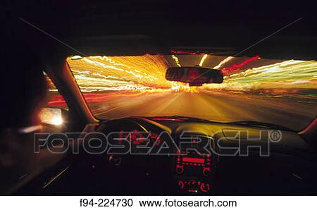 Stock Image - View from inside car, with blurred lights and traffic in the distance. Fotosearch