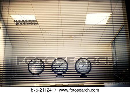 View from the outside of the inside of an office with three clocks hanging on a wall, with different schedules of New York, Limerick and Tokyo. London, England, UK, Europe. View Large Photo Image Stock Photo - View from the outside of the inside of an office with three clocks hanging on a wall, with different schedules of New York, Limerick and Tokyo. London, England, UK, Europe.. Fotosearch
