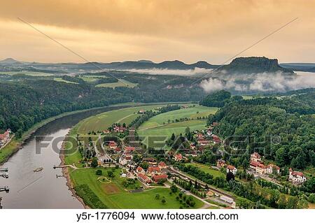 Picture - View from the spectacular rock formation Bastei Bastion in the national park Saxony Switzerland to the health resort Rathen Oberrathen and to Elbe River In the background is the Table Mountain Lilienstein. Fotosearch