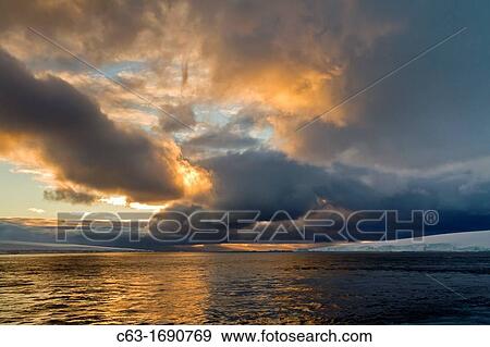 View of dramatic skies at sunset in Antarctic Sound, Antarctica View Large Photo Image Stock Photo - View of dramatic skies at sunset in Antarctic Sound, Antarctica. Fotosearch