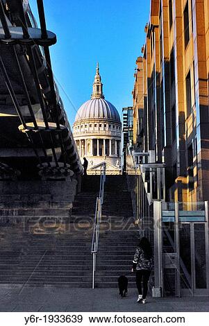 View of St. Paul's Cathedral from the banks of the River Thames by the Millenium Bridge (seen on the left-hand side) including street vendor on Peter's Hill and pedestrian walking dog, on a sunny Spring evening in London, England. View Large Photo Image Stock Photo - View of St. Paul's Cathedral from the banks of the River Thames by the Millenium Bridge (seen on the left-hand side) including street vendor on Peter's Hill and pedestrian walking dog, on a sunny Spring evening in London, England.. Fotosearch