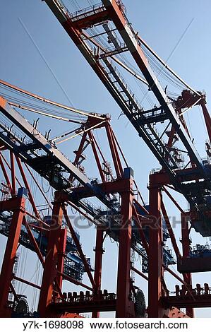 Stock Photo - View of the activities, logistic and technical equipment of the Port of Hamburg along the river Elbe, Germany. Fotosearch