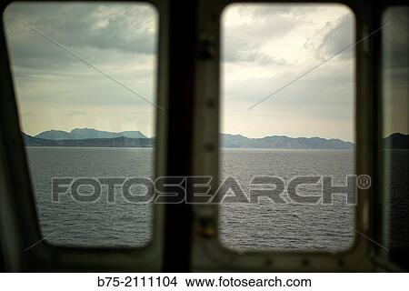 View of the sea, land and the sky through a window of a boat. Croosing the Mediterranean Sea from Ciutadella, Aberdeen to Alcudia, Mallorca, Balearic Islands, Spain View Large Photo Image Picture - View of the sea, land and the sky through a window of a boat. Croosing the Mediterranean Sea from Ciutadella, Aberdeen to Alcudia, Mallorca, Balearic Islands, Spain. Fotosearch