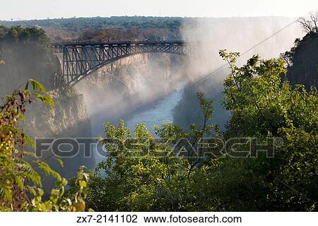 Views of Victoria Falls. Behind, the bridge between Zambia and Zimbabwe. View Large Photo Image Stock Image - Views of Victoria Falls. Behind, the bridge between Zambia and Zimbabwe.. Fotosearch