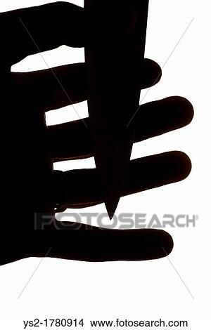 Violent scene with dagger pressed against fingers of a mans hand View Large Photo Image Picture - Violent scene with dagger pressed against fingers of a mans hand. Fotosearch