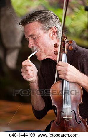 Violin player lighting cigarette View Large Photo Image Stock Photo - Violin player lighting cigarette. Fotosearch