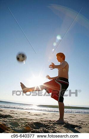 Stock Photo - Virginia Beach, Virginia, USA, boy playing on the beach, 13 years old.. Fotosearch