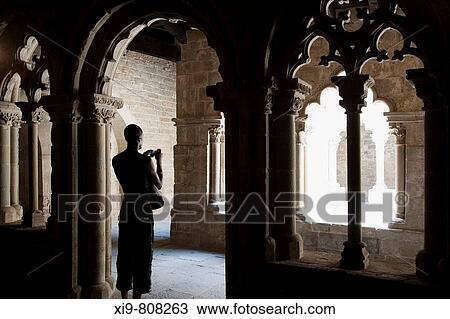 Stock Image - Visitor taking pictures in the cloister of the Sant Pau del Camp Benedictine monastery, Barcelona. Catalonia, Spain. Fotosearch