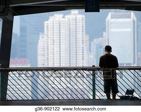 Stock Image - Visitors view harbor in Hong Kong, China. Fotosearch