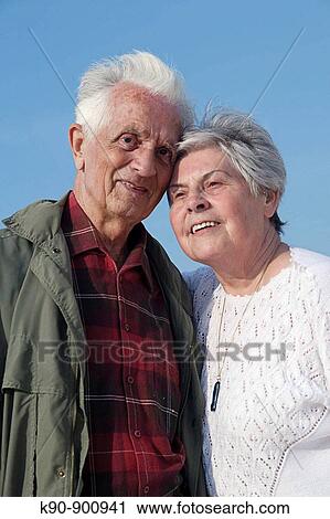 Waist up photograph of elderly caucasian couple leaning at each other head to head and looking at the camera with blue sky, Island of Amrum, Northfrisian, Schleswig-Holstein, Northern Germany, Europe View Large Photo Image Stock Image - Waist up photograph of elderly caucasian couple leaning at each other head to head and looking at the camera with blue sky, Island of Amrum, Northfrisian, Schleswig-Holstein, Northern Germany, Europe. Fotosearch