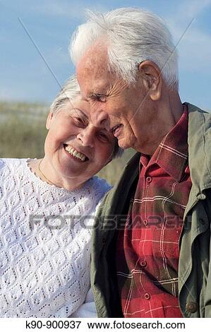 Waist up photograph of elderly caucasian couple leaning head to head at each other with blue sky, Island of Amrum, Northfrisian, Schleswig_Holstein, Northern Germany, Europe View Large Photo Image Stock Photo - Waist up photograph of elderly caucasian couple leaning head to head at each other with blue sky, Island of Amrum, Northfrisian, Schleswig_Holstein, Northern Germany, Europe. Fotosearch