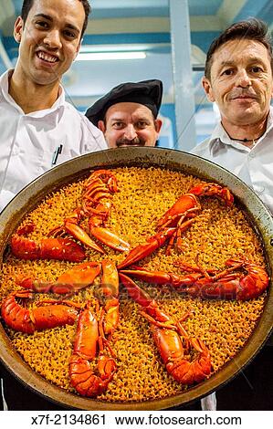 Waiters show a paella. In La Pepica restaurant, 6 Passeig Nept, Malvarrosa beach. Valencia, Spain. View Large Photo Image Stock Image - Waiters show a paella. In La Pepica restaurant, 6 Passeig Nept, Malvarrosa beach. Valencia, Spain.. Fotosearch