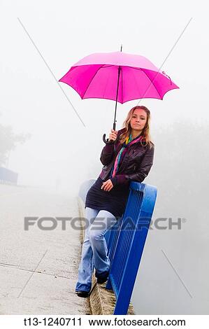 Waiting on a bridge with an umbrella in hand young woman View Large Photo Image Stock Image - Waiting on a bridge with an umbrella in hand young woman. Fotosearch