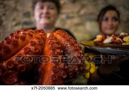 Stock Photography - Waitresses showing at left Octopus and at right? Pulpo a feira? octopus in Galician style, Corua city, Galicia, Spain. Fotosearch
