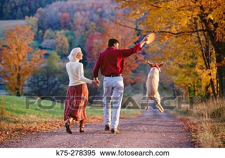 Stock Photography - Walking with their dog on a country road. Fotosearch