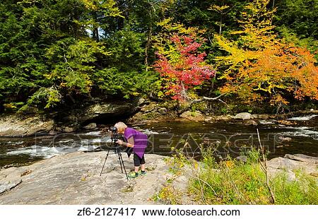 Waterville Vermont tourist taking pictures on falls under covered bridge Montgomery Covered Bridge with fall foliage in Northern New England 3. View Large Photo Image Stock Photo - Waterville Vermont tourist taking pictures on falls under covered bridge Montgomery Covered Bridge with fall foliage in Northern New England 3.. Fotosearch
