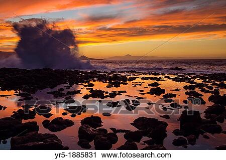 Wave breaking at El Confital on north coast of Gran Canaria, Canary Islands, Spain Tenerife in distance View Large Photo Image Stock Image - Wave breaking at El Confital on north coast of Gran Canaria, Canary Islands, Spain Tenerife in distance. Fotosearch