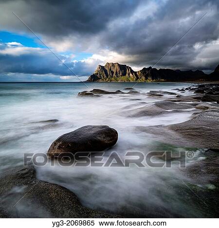 Stock Photography - Waves break across rocky coastline at Unstad beach, Vestvagoy, Lofoten Islands, Norway.. Fotosearch