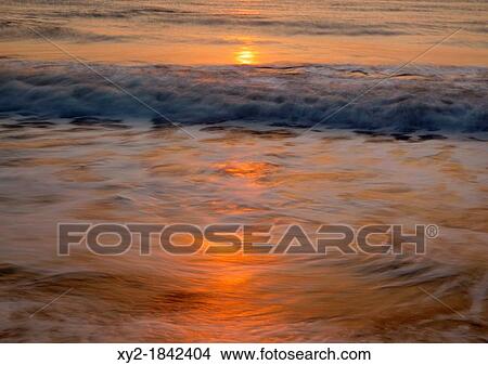 Waves breaking near shore at sunrise View Large Photo Image Picture - Waves breaking near shore at sunrise. Fotosearch