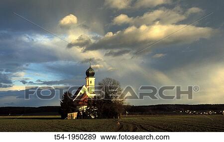 Stock Photo - Weather mood before a small chapel. Fotosearch