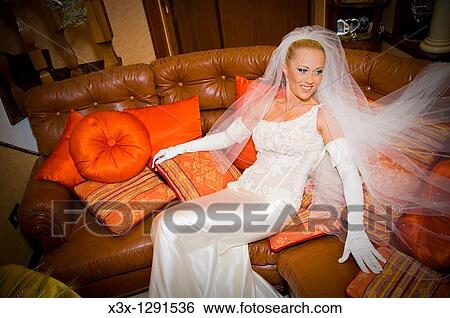 Stock Photograph - Wedding bride sitting on couch. Fotosearch
