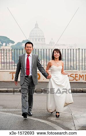 Wedding couple crossing the street in front of Saint Peter's dome in Rome Italy View Large Photo Image Stock Image - Wedding couple crossing the street in front of Saint Peter's dome in Rome Italy. Fotosearch