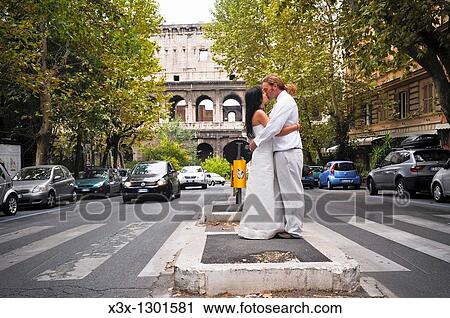 Wedding couple kissing in the streets of Rome Italy with the Roman Coliseum in the background View Large Photo Image Stock Image - Wedding couple kissing in the streets of Rome Italy with the Roman Coliseum in the background. Fotosearch
