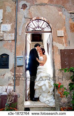 Wedding couple kissing on a doorstep View Large Photo Image Picture - Wedding couple kissing on a doorstep. Fotosearch