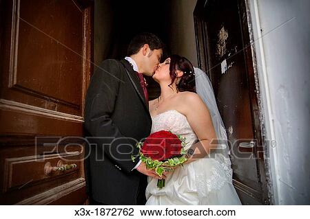 Stock Image - Wedding couple kissing on a doorstep. Fotosearch
