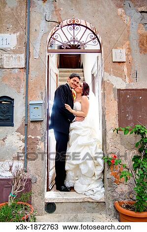 Wedding couple kissing on a doorstep View Large Photo Image Stock Image - Wedding couple kissing on a doorstep. Fotosearch