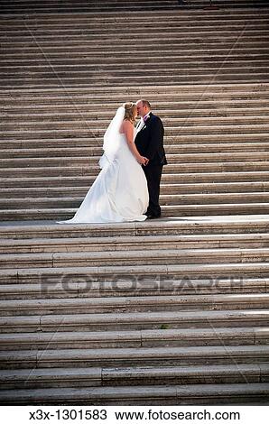 Wedding couple kissing on stairs View Large Photo Image Stock Image - Wedding couple kissing on stairs. Fotosearch