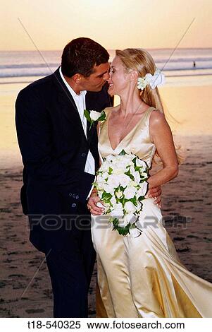 wedding couple kissing with beach and sunset in the background View Large Photo Image Stock Photography - wedding couple kissing with beach and sunset in the background. Fotosearch
