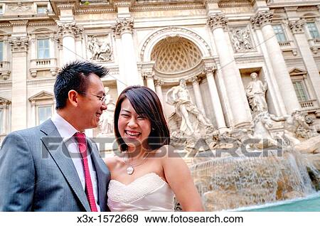 Wedding couple laughing in front of Fontana di Trevi in Rome Italy View Large Photo Image Stock Photo - Wedding couple laughing in front of Fontana di Trevi in Rome Italy. Fotosearch