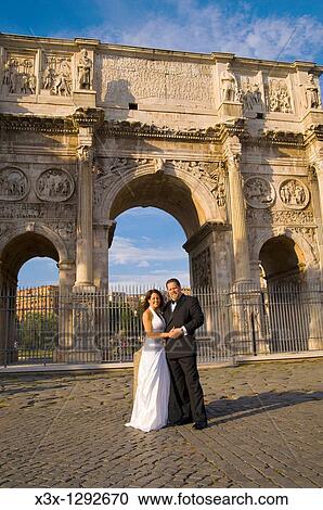 Stock Image - Wedding couple standing in front of the Constantine's arc in Rome Italy. Fotosearch