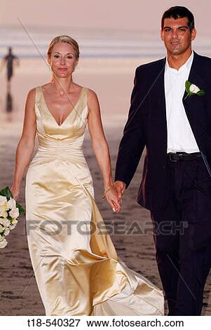 wedding couple walking and holding hands on the beach View Large Photo Image Stock Photo - wedding couple walking and holding hands on the beach. Fotosearch