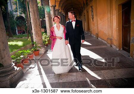Wedding couple walking under a cloister Rome Italy View Large Photo Image Stock Photo - Wedding couple walking under a cloister Rome Italy. Fotosearch