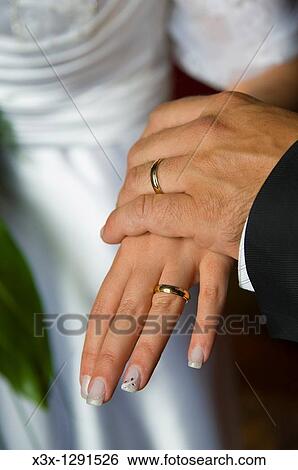 Stock Photograph - Wedding rings on each other hands. Fotosearch