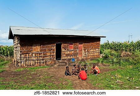 Stock Image - Weliata Sodo Ethiopia Africa Gamo tribe home with children playing game in front of poor farm house 10. Fotosearch