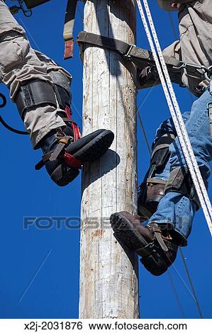 Westland, Michigan - Electric utility linemen climb poles to make repairs during the annual Michigan Lineman's Rodeo, a competition for workers from various Michigan utility companies. View Large Photo Image Stock Photograph - Westland, Michigan - Electric utility linemen climb poles to make repairs during the annual Michigan Lineman's Rodeo, a competition for workers from various Michigan utility companies.. Fotosearch