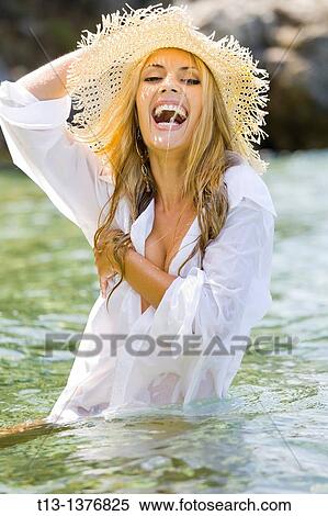 Wet in men's shirt happy young woman in the water View Large Photo Image Stock Photography - Wet in men's shirt happy young woman in the water. Fotosearch