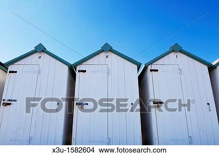 White beach huts under a clear blue sky at Budleigh Salterton, Devon, England, United Kingdom View Large Photo Image Picture - White beach huts under a clear blue sky at Budleigh Salterton, Devon, England, United Kingdom. Fotosearch