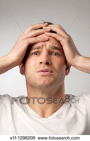 Stock Photo - White caucasian male man suffering with a headache sore head hangover.. Fotosearch