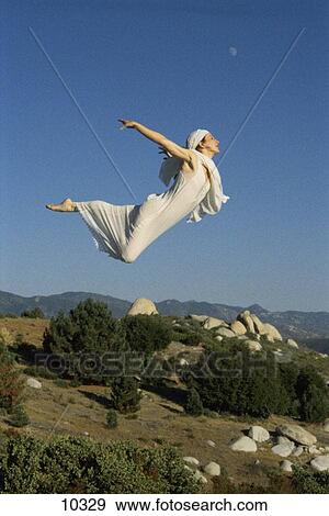 White clad woman flying over mountain with moon above in color View Large Photo Image Stock Photo - White clad woman flying over mountain with moon above in color. Fotosearch