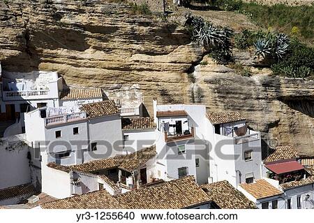 White homes constructed in caves sit under huge rocks in Setenil de las Bodegas village, Cadiz province, Andalusia, Spain. View Large Photo Image Stock Image - White homes constructed in caves sit under huge rocks in Setenil de las Bodegas village, Cadiz province, Andalusia, Spain.. Fotosearch