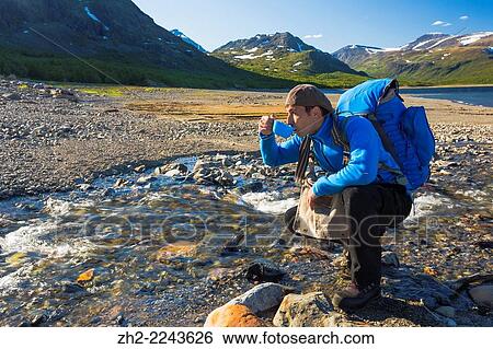 White man hiking and drinking water from a creek in stora sjofallets national park, G? llivare, Swedish lapland. View Large Photo Image Stock Photograph - White man hiking and drinking water from a creek in stora sjofallets national park, G? llivare, Swedish lapland.. Fotosearch
