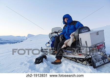 White man sitting on snowmobile at sarek national park with mount Skerfe in the background in winter time View Large Photo Image Stock Image - White man sitting on snowmobile at sarek national park with mount Skerfe in the background in winter time. Fotosearch