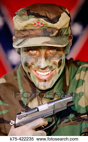 Stock Photography - White supremist militia member with 9mm pistol. Fotosearch