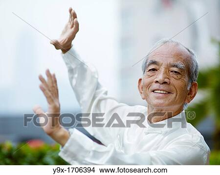 William Ng, a Tai Chi master practicing Tai Chi on the deck of The Peninsula Hotel, overlooking Hong Kong Victoria Harbour skyline View Large Photo Image Picture - William Ng, a Tai Chi master practicing Tai Chi on the deck of The Peninsula Hotel, overlooking Hong Kong Victoria Harbour skyline. Fotosearch